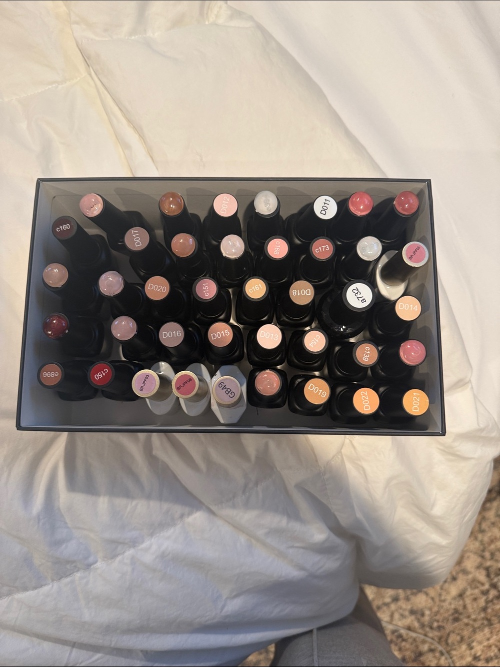 Collection of gel, nail polishes. Mostly light neutrals and dark neutrals.